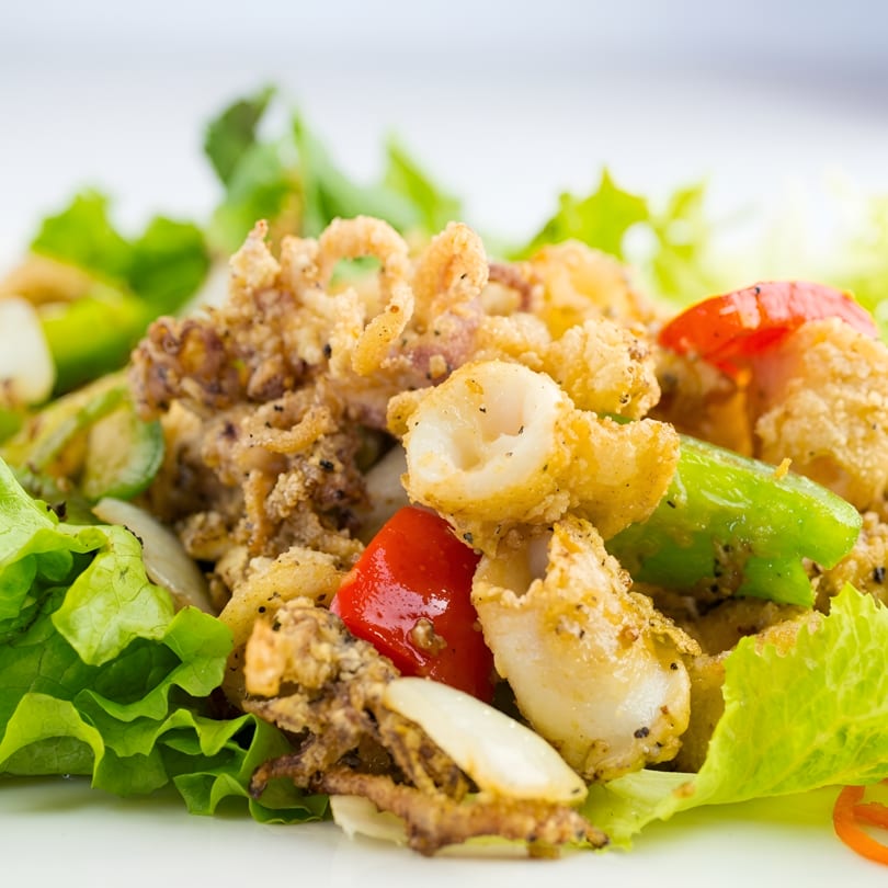 Crispy fried calamari with red and green bell peppers, onions, and fresh lettuce.